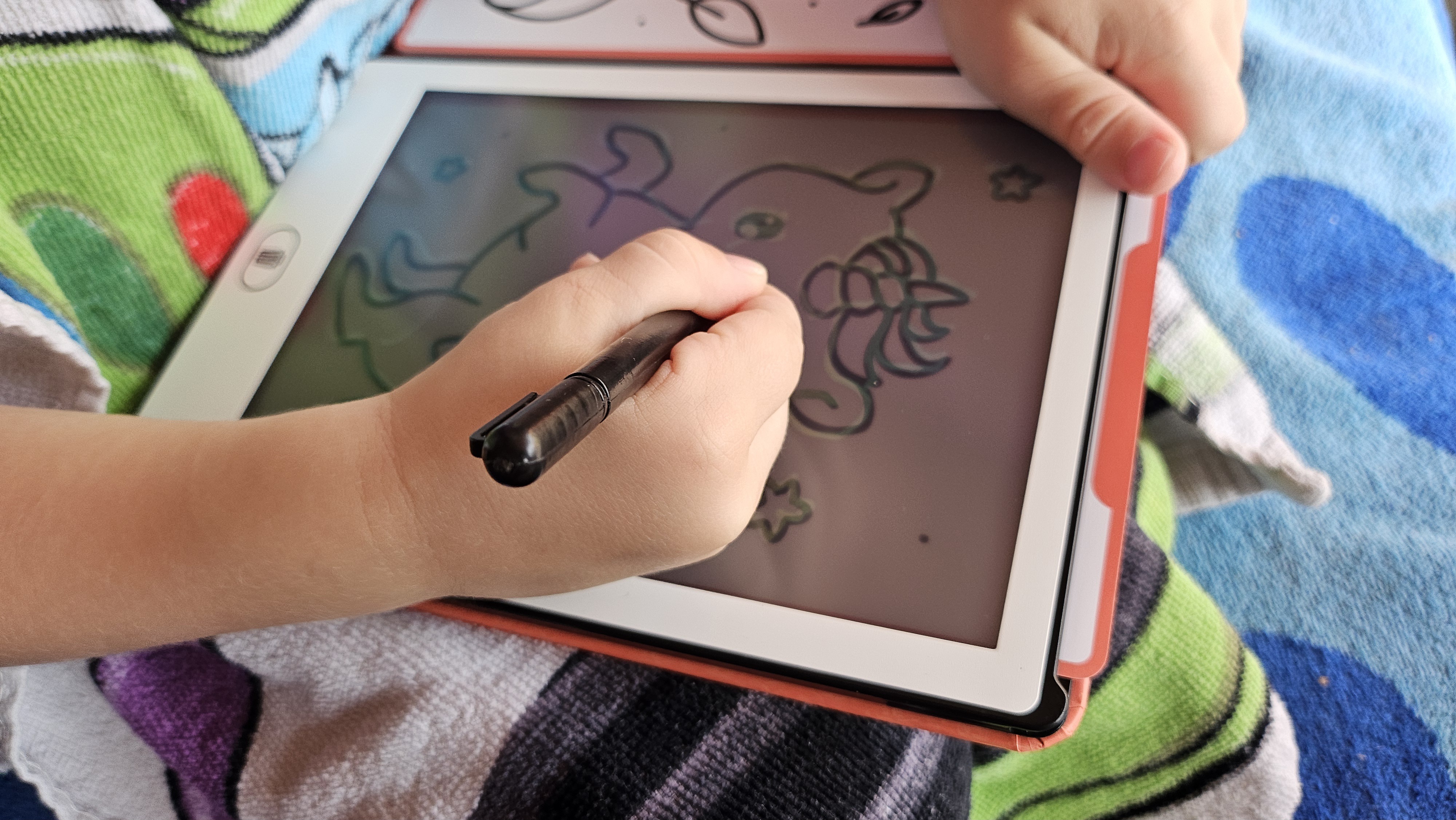 KidyDraw Mini op schoot in de tuin, kleuter tekent met de lichtpen
