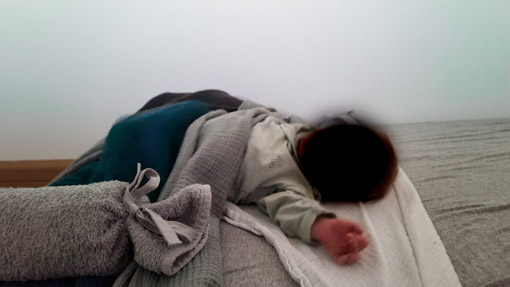 Newborn baby slaapt in montessori vloerbed