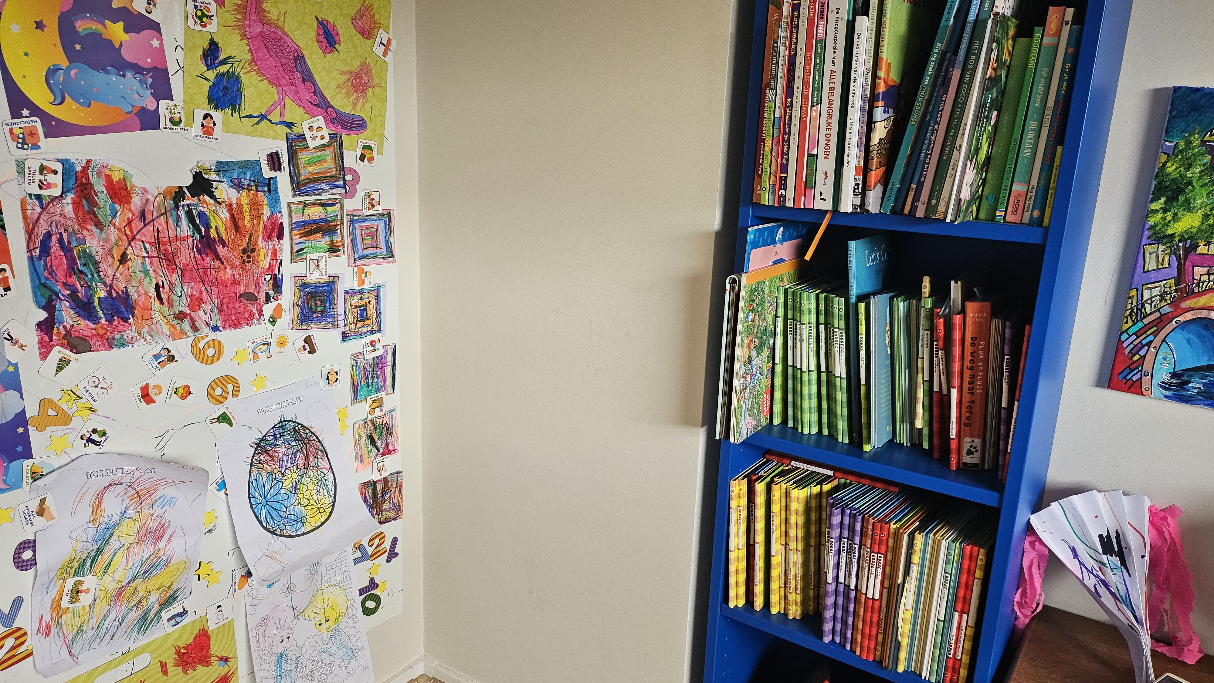 Tekeningen opgehangen aan een boekenkast